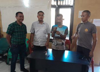 Tersangka saat di kantor polisi.