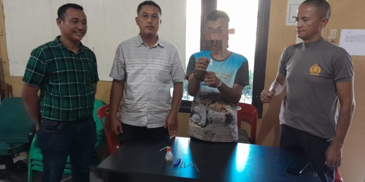 Tersangka saat di kantor polisi.