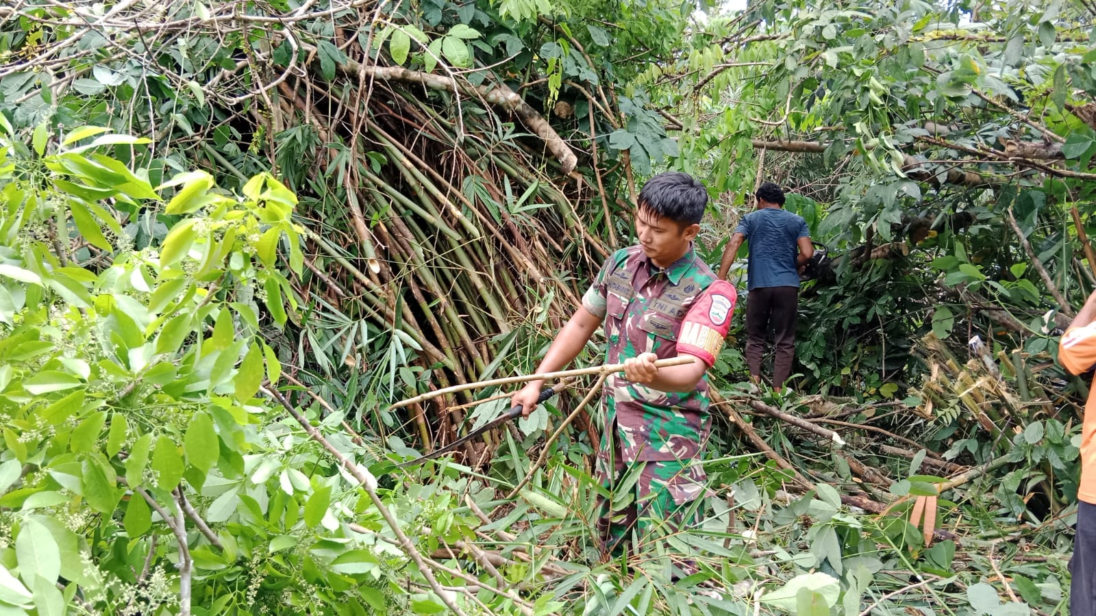 (Rey Simorangkir/TASLABNEWS)Babinsa Koramil 05/Kolang, Serda Charly Hutabarat bersama warga membersihkan aliran Sungai Unte Mungkur IV, Kabupaten Tapteng, Kamis (13/04/2023).