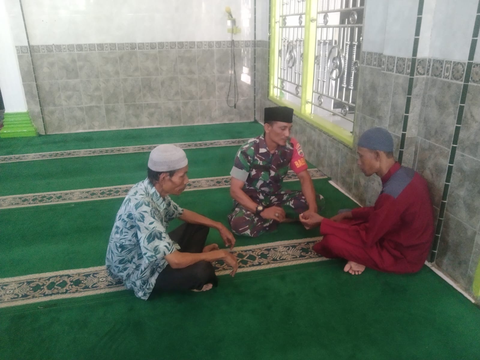 (Rey Simorangkir/TASLABNEWS)Babinsa Koramil 06/Kota, Serda Alamsyah mengajarkan anak-anak membaca Al-Qur'an di Masjid Itidal Kota Sibolga. 