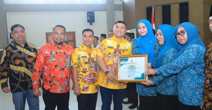 Bupati Labura, Hendriyanto Sitorus, menyerahkan penghargaan kepada organisasi yang turut berperan penurunan stunting  