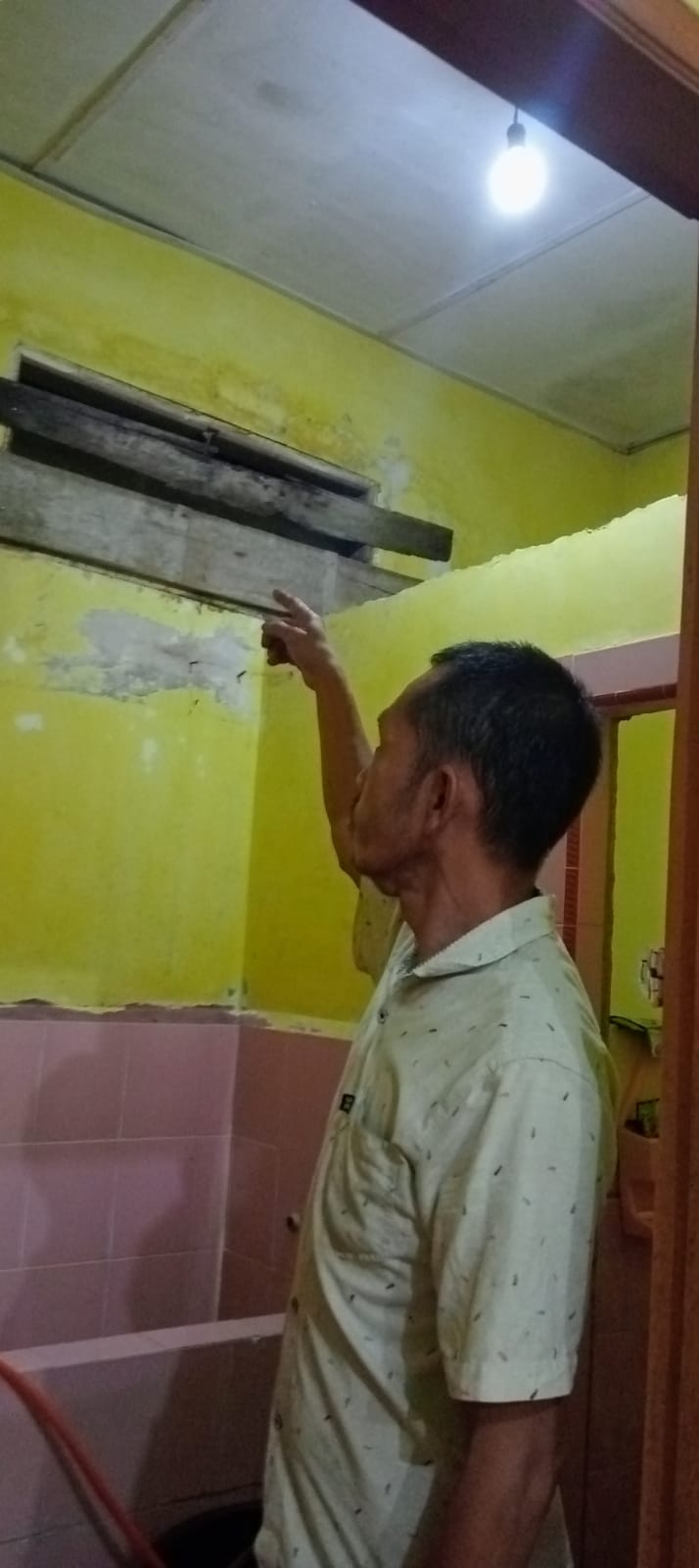 Warga menunjukkan lokasi yang diduga tempat tersangka masuk ke dalam rumah korban.