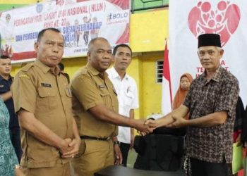 Plt Kadis Sosial Syahrizal Hasibuan saat memberikan santunan kepada lansia. 