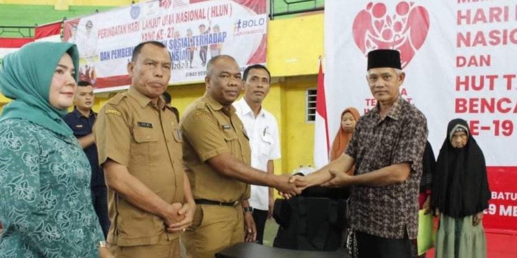 Plt Kadis Sosial Syahrizal Hasibuan saat memberikan santunan kepada lansia. 