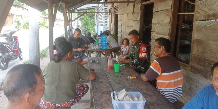 Babinsa Koramil 05/Kolang, Serda Kepler Situmorang saling bertukar pikiran dan bersendau gurau dengan warga di Desa Simarpinggan, Kabupaten Tapteng.