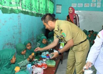 Wakil Bupati Labura, H. Samsul Tanjung menyerahkan makanan tambahan kepada siswa PAUD