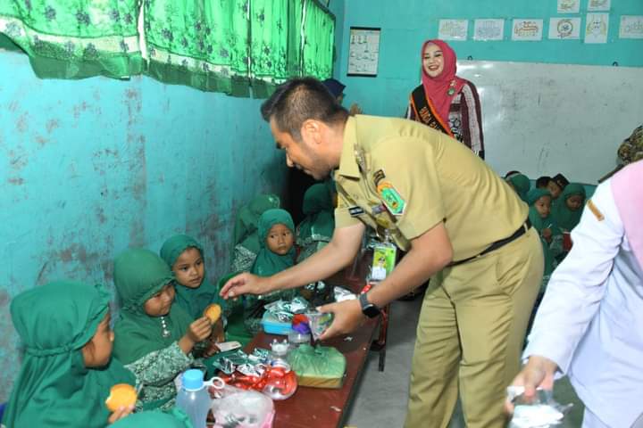 Wakil Bupati Labura, H. Samsul Tanjung menyerahkan makanan tambahan kepada siswa PAUD