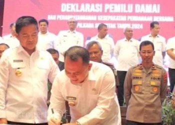 Bupati Labuhanbatu H Erik Adtrada Ritonga saat menandatangani MoU Pilkada damai. 