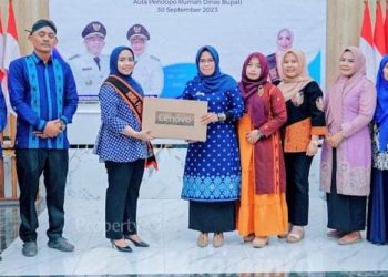 Ketua Bunda PAUD Labuhanbatu dr. Hj. Maya Hasmita Sp, OG, MKM didampingi Kepala Dinas PMD Labuhanbatu Menyerahkan Dua Buah Unit Laptop.