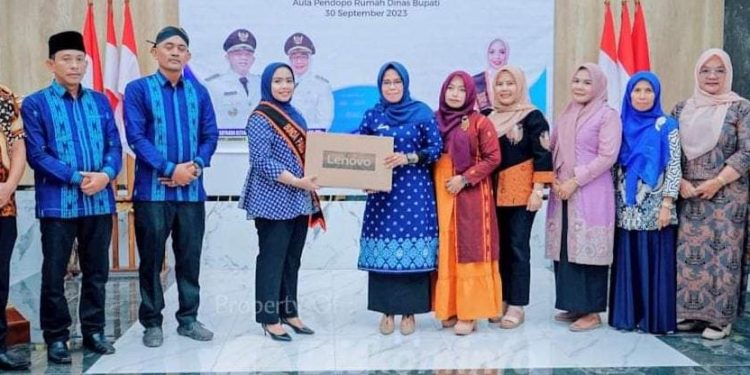 Ketua Bunda PAUD Labuhanbatu dr. Hj. Maya Hasmita Sp, OG, MKM didampingi Kepala Dinas PMD Labuhanbatu Menyerahkan Dua Buah Unit Laptop.