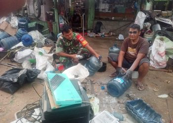Babinsa Bantu Warga Bersihkan Barang Rusak