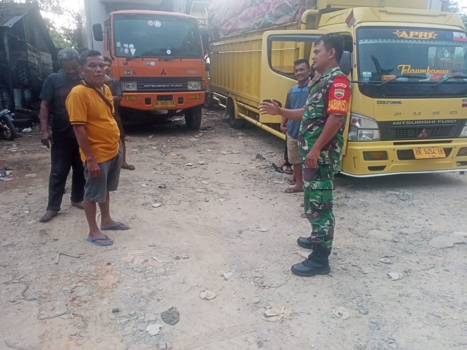 Babinsa Koramil 06/Kota, Serda Ashadi Pasaribu saat menyampaikan pesan keselamatan berlalu lintas kepada para supir truk di Kelurahan Simare-mare, Kota Sibolga.