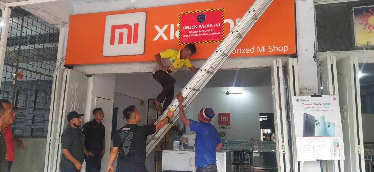 Pegawai Bapenda Labuhanbatu saat melakukan penertiban objek pajak reklame.