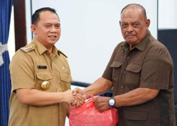 Bupati Labuhanbatu H Erik Adtrada Ritonga (kiri) saat menyerahkan tali asih kepada salahseorang veteran di Labuhanbatu.