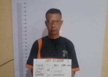 Tersangka saat di kantor polisi.