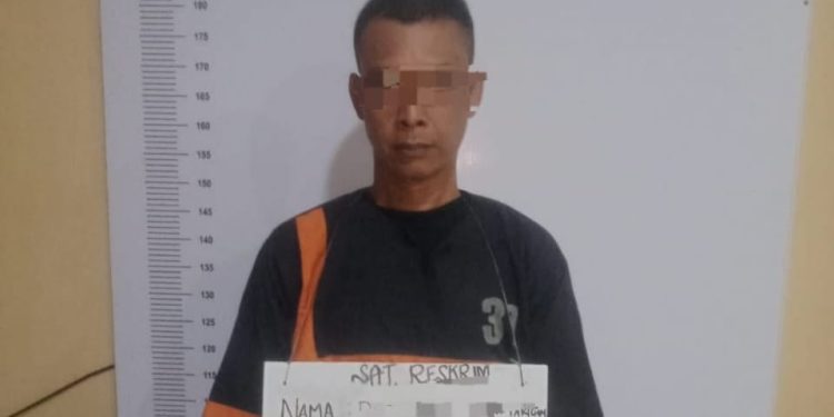 Tersangka saat di kantor polisi.