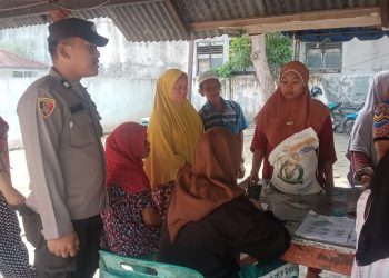 Personel Polres Tanjungbalai Amankan Penyaluran Beras ke Warga