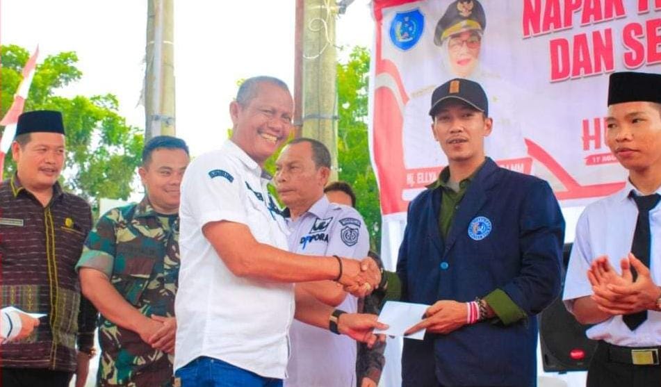 Sarimpunan Ritonga (kiri) memberikan cinderamata kepada salahseorang generasi muda yang turut serta pada kegiatan tersebut.