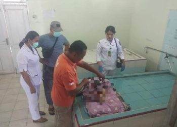 Pihak kepolisian dan tim medis memeriksa kondisi korban