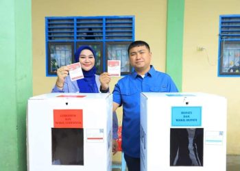 Bupati Labura, Dr. Hendriyanto Sitorus, dan istri memberikan hak suaranya di TPS 002 Aek Kanopan Timur