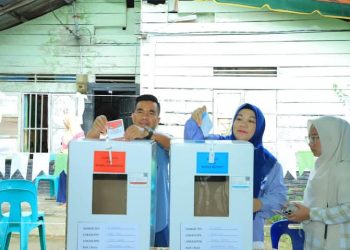 Wakil Bupati Labura, H. Samsul Tanjung bersama istri menggunakan hak suaranya di TPS 006, Desa Sidua-dua.