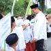 Bupati Labura, Dr. Hendri Yanto Sitorus, disambut siswa saat menghadiri MTQ Ke-XI dan FSQ Ke-X di Desa Simangalam, Rabu (12/2/2025)