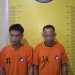 Dua tersangka saat di kantor polisi.