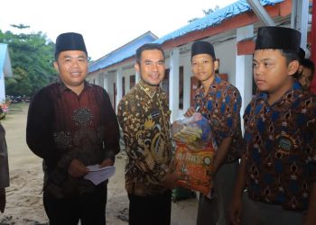 Wakil Bupati Labura, H. Samsul Tanjung, menyerahkan santunan kepada anak yatim piatu.