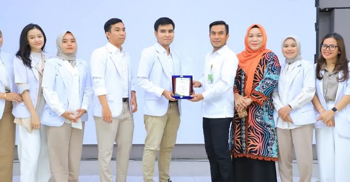 Wakil Bupati Labura, H. Samsul Tanjung, menyerahkan plakat ucapan terima kasih kepada dokter internship yang telah selesai praktek.