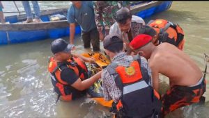 Warga menyaksikan evakuasi mayat korban yang hanyut di sungai.