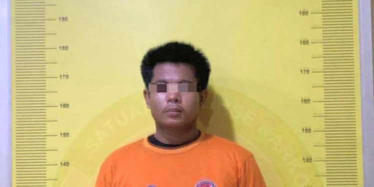 Tersangka saat di kantor polisi.