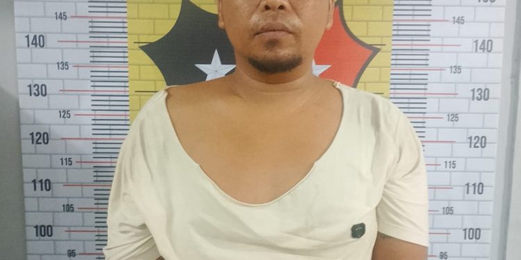 Tersangka saat di kantor polisi.