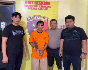 Tersangka saat di kantor polisi. 