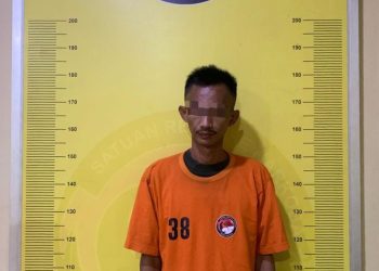 Tersangka saat di kantor polisi.