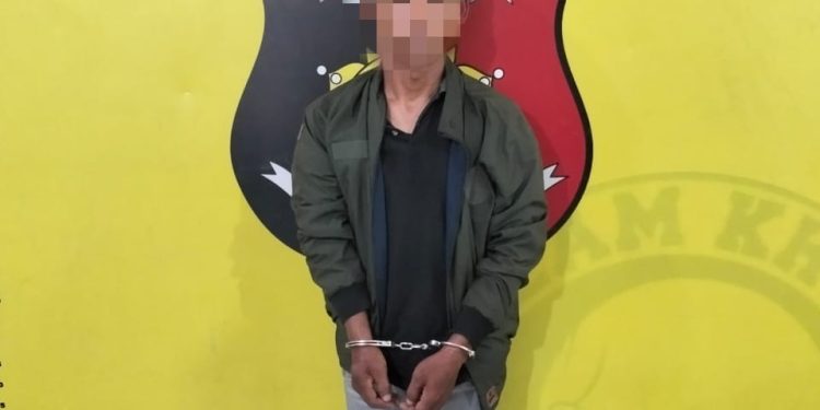 Tersangka saat di kantor polisi.