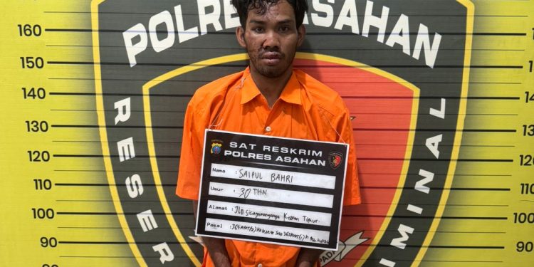 Tersangka saat di kantor polisi.