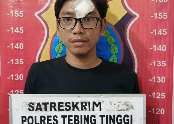 Tersangka penggelapan sepedamotor saat di kantor polisi.