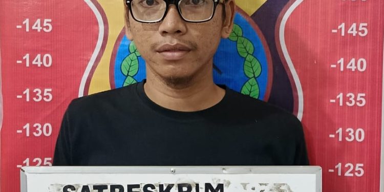 Tersangka penggelapan sepedamotor saat di kantor polisi.