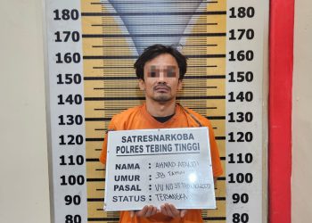 Tersangka saat di kantor polisi.