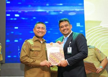 Hendri Yanto Sitorus foto bersama Gubsu Bobby Nasution usai acara peluncuran UHC. 