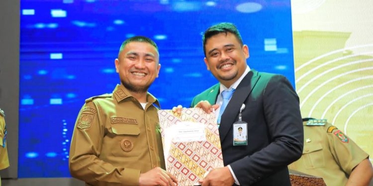 Hendri Yanto Sitorus foto bersama Gubsu Bobby Nasution usai acara peluncuran UHC. 