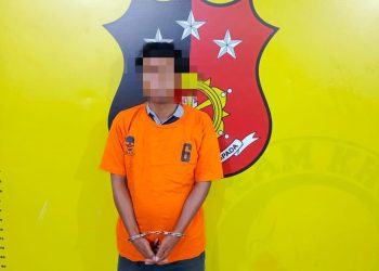 Tersangka saat di kantor polisi.