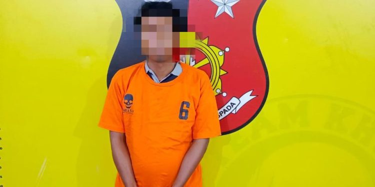 Tersangka saat di kantor polisi.