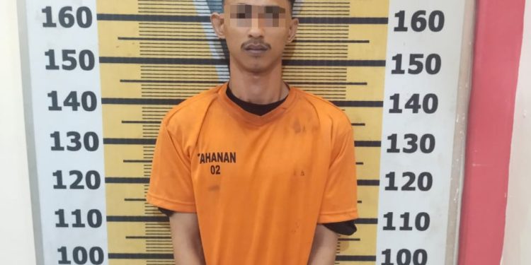 Tersangka saat di kantor polisi.