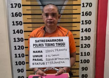 Tersangka saat di kantor polisi.