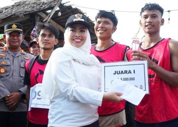 Bupati Labuhanbatu dr Hj Maya Hasmita saat menyerahkan hadiah kepada pemenang festival lomba dayung sampan yang di gelar di Kecamatan Panai Hulu. 