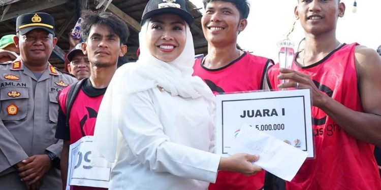 Bupati Labuhanbatu dr Hj Maya Hasmita saat menyerahkan hadiah kepada pemenang festival lomba dayung sampan yang di gelar di Kecamatan Panai Hulu.