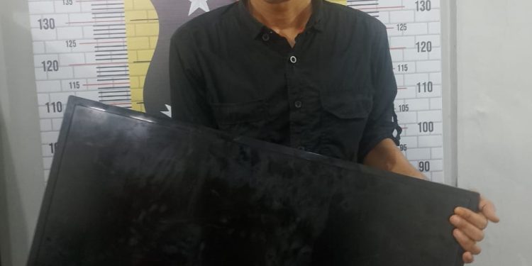 Tersangka saat di kantor polisi.