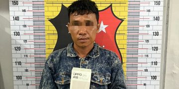 Tersangka saat di kantor polisi.