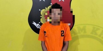 Tersangka saat di kantor polisi.